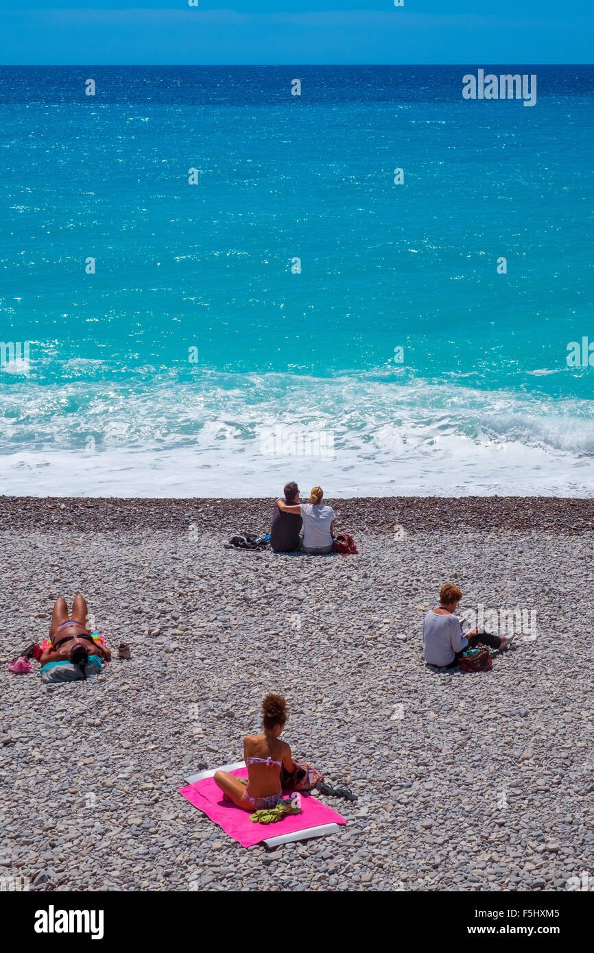 La gente tomar el sol tumbado en la playa de grava sol mar arena Foto de stock