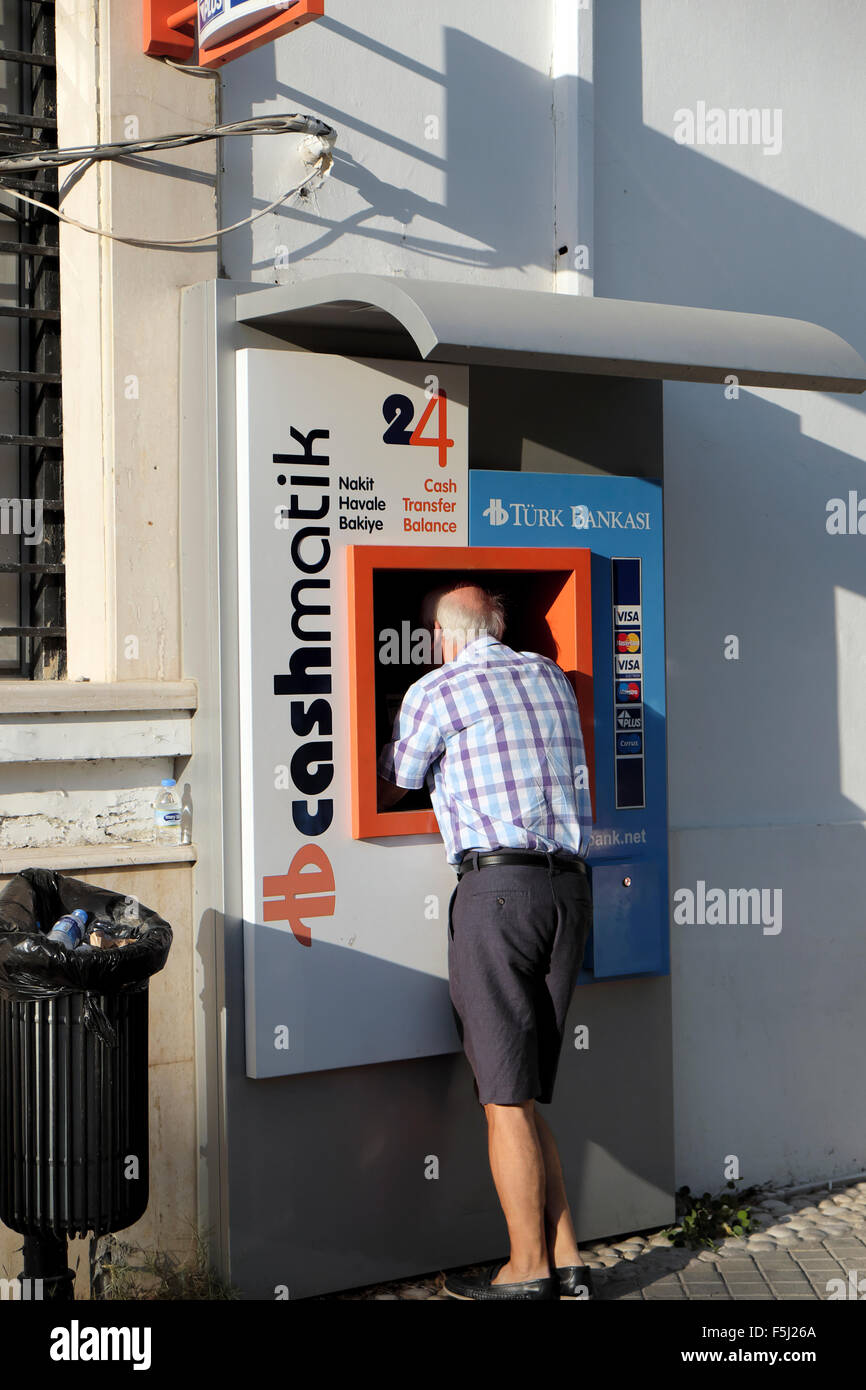 Un hombre usando el turco cashmatik Bankasi cajero ATM en Kyrenia Girne en turco de Chipre Septentrional KATHY DEWITT Foto de stock