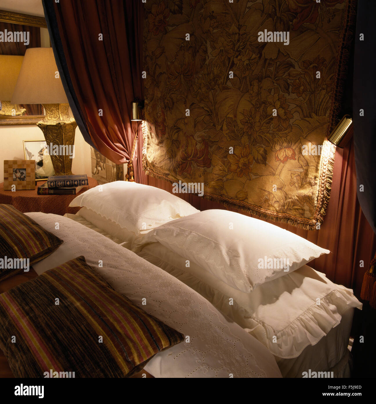 Rica trama colgando encima de la cama con sábanas almohadas blancas en un 80  dormitorio Fotografía de stock - Alamy
