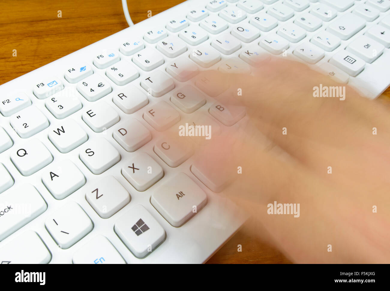 Escribir rápido en el teclado de una computadora con los mecanógrafos mano borrosa para deducir la velocidad. Foto de stock