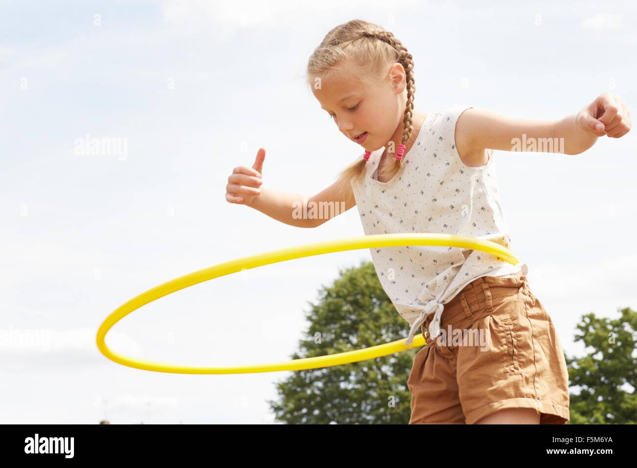 Niña con hula hoop en el brazo en un parque Fotografía de stock - Alamy