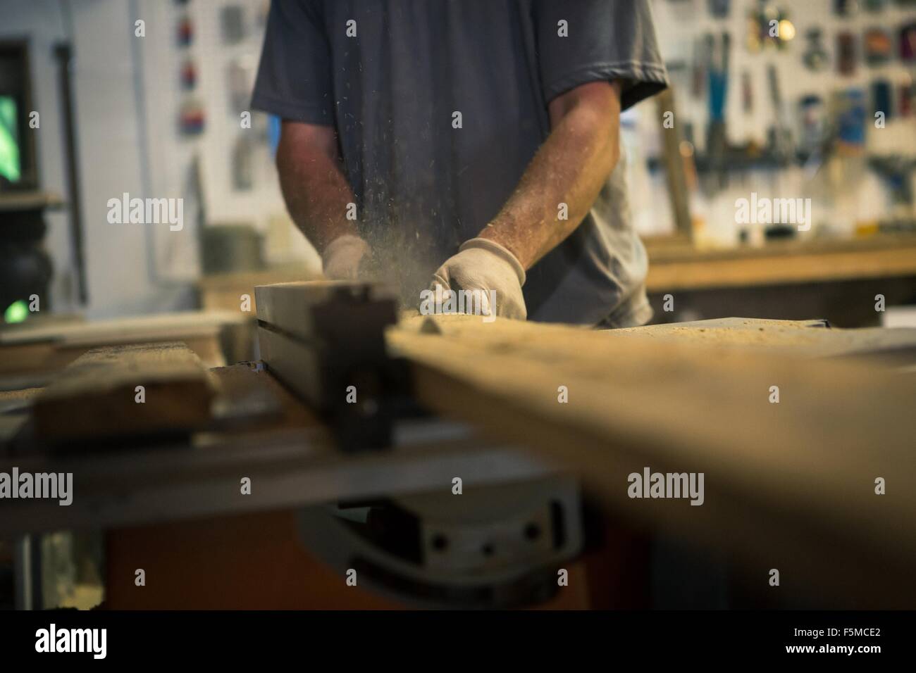 Artista de madera en el taller, utilizando maquinaria, sección intermedia Foto de stock