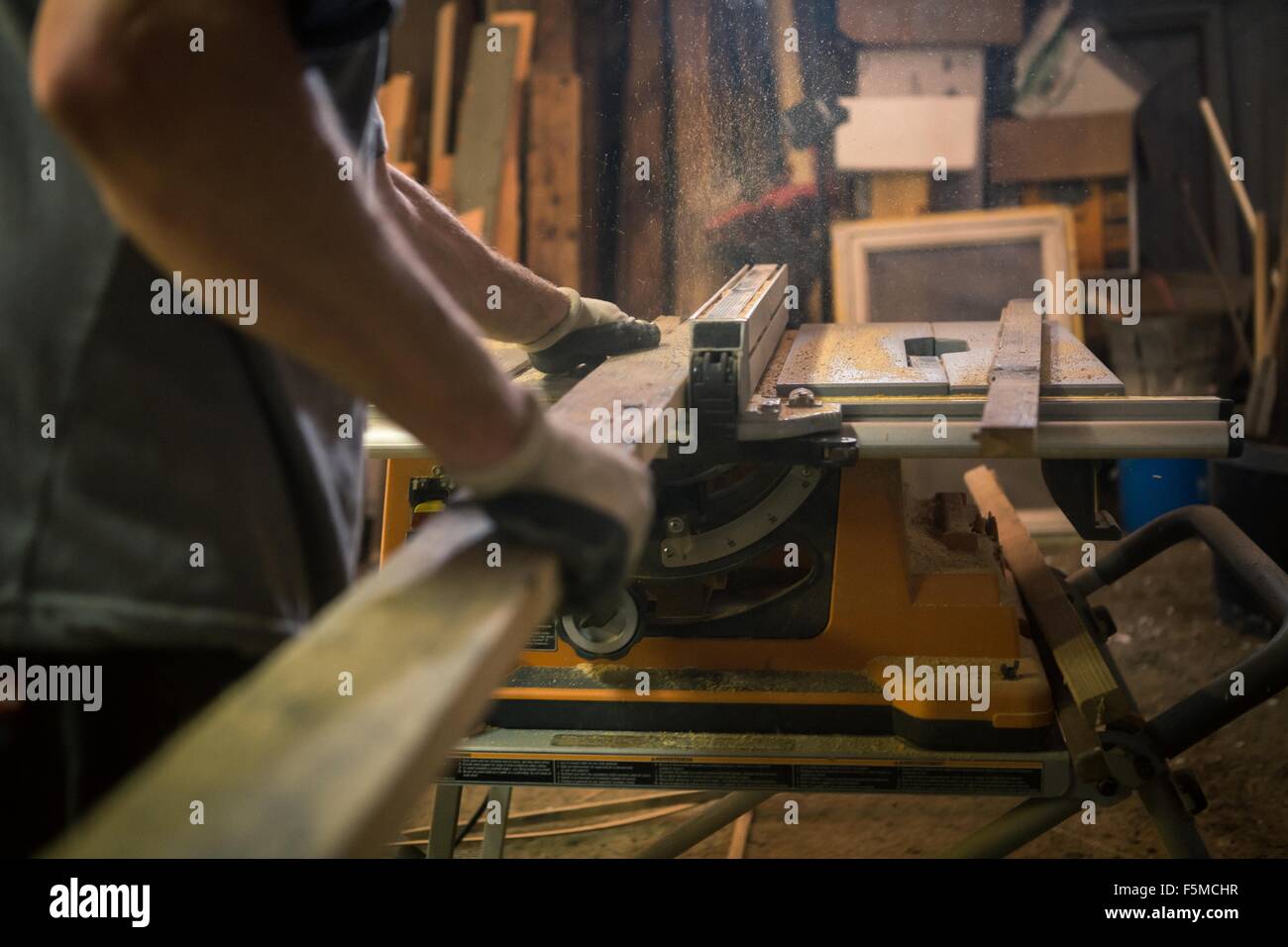 Artista de madera en el taller, utilizando maquinaria, sección intermedia Foto de stock