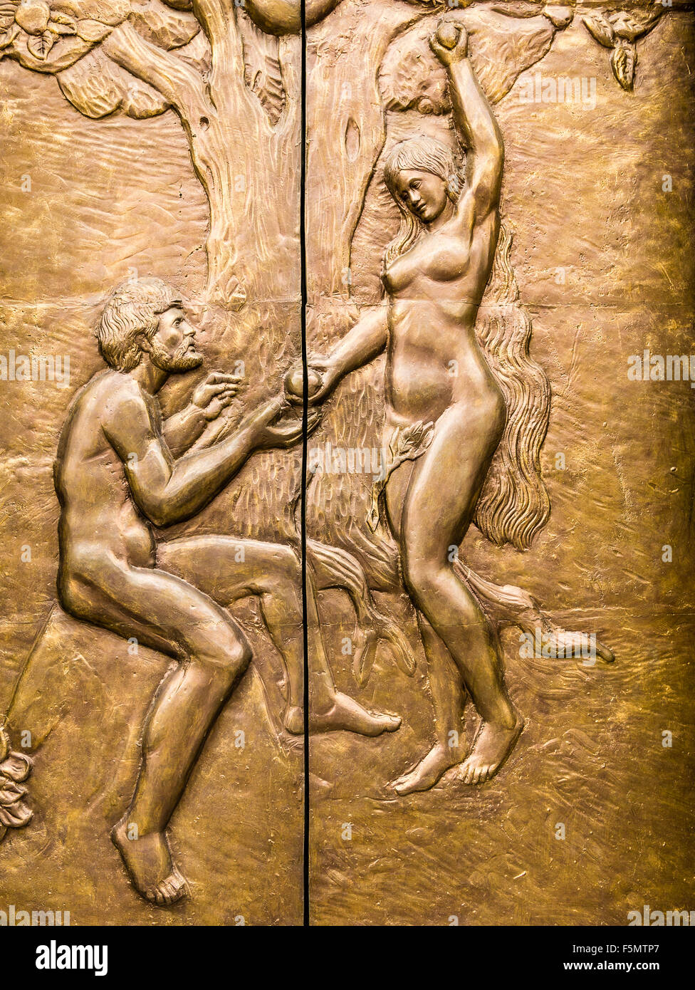 Cobre en alto relieve que representan Eva ofrece el fruto prohibido de Adán. Foto de stock