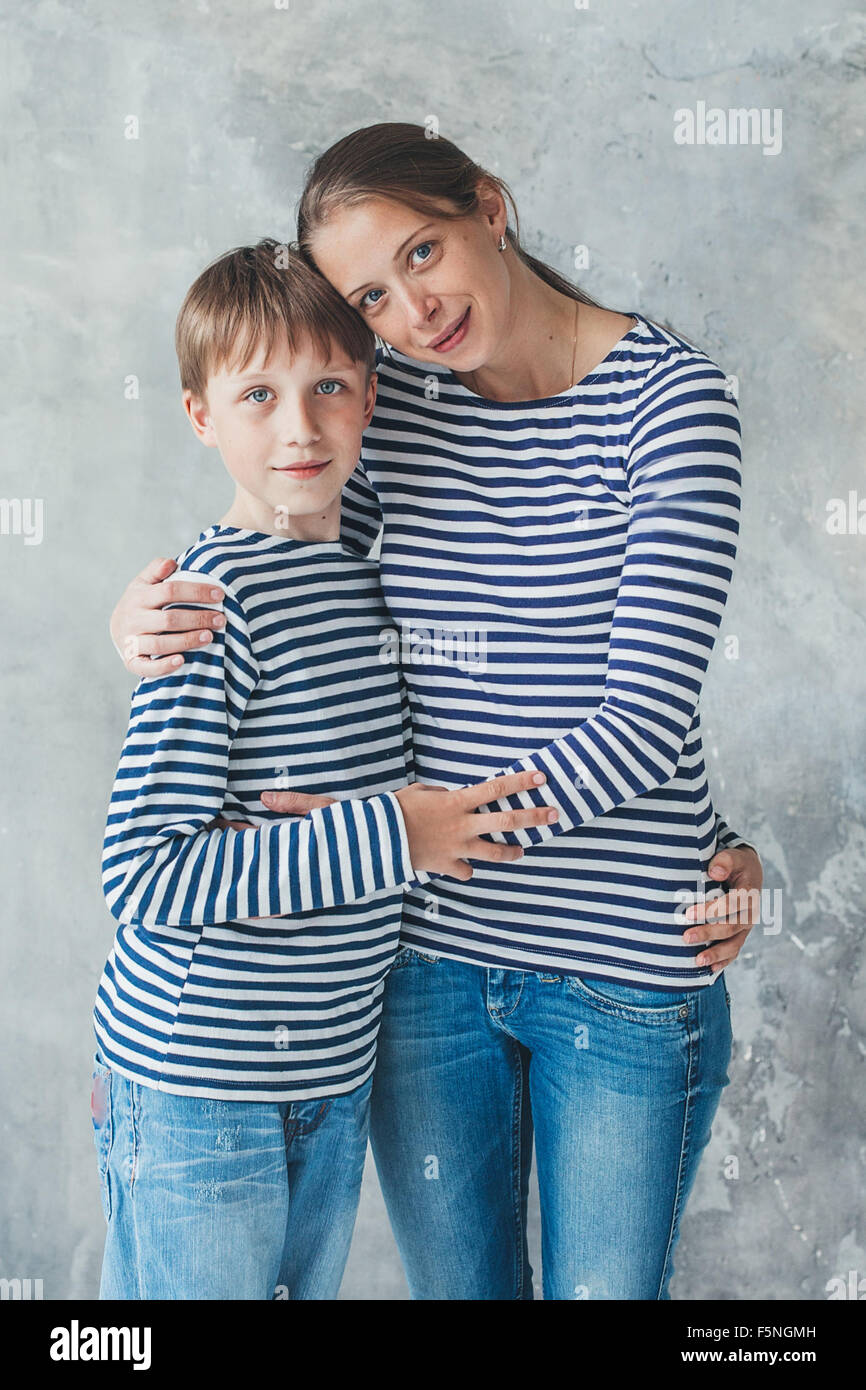 Madre de familia con hijo de igual longitud completa de ropa de moda a  rayas en la pared gris antecedentes studio Fotografía de stock - Alamy