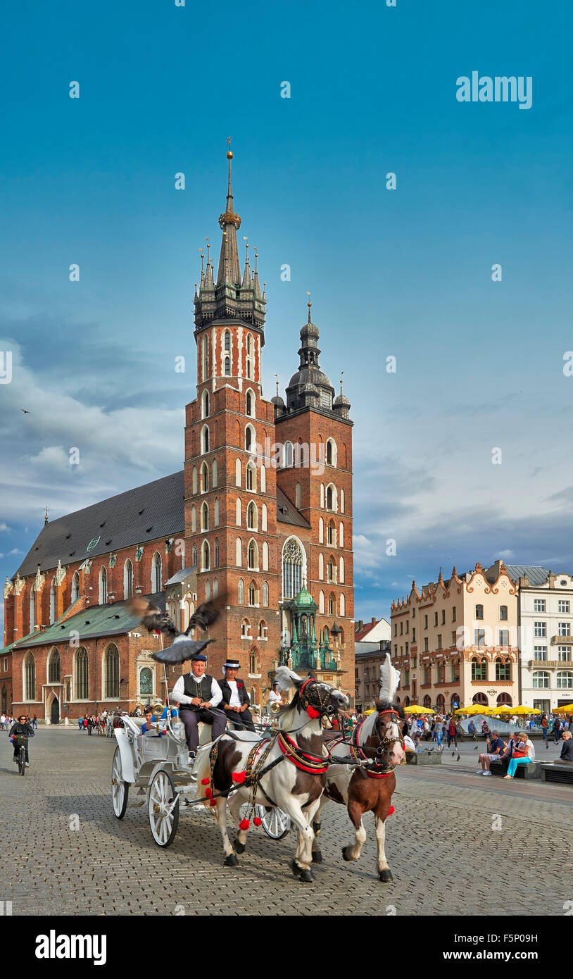 Calesa en frente de la Iglesia de Nuestra Señora Asunta al cielo o la Basílica de Santa María en la plaza del mercado de Cracovia, Polonia Foto de stock