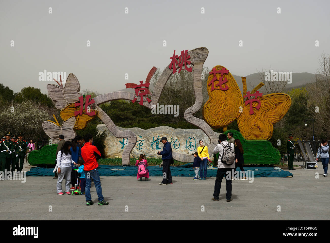 Las personas turistas plantean posando fotos Jardín Botánico de Beijing el smog niebla día señal de entrada signeage Floral RM Foto de stock