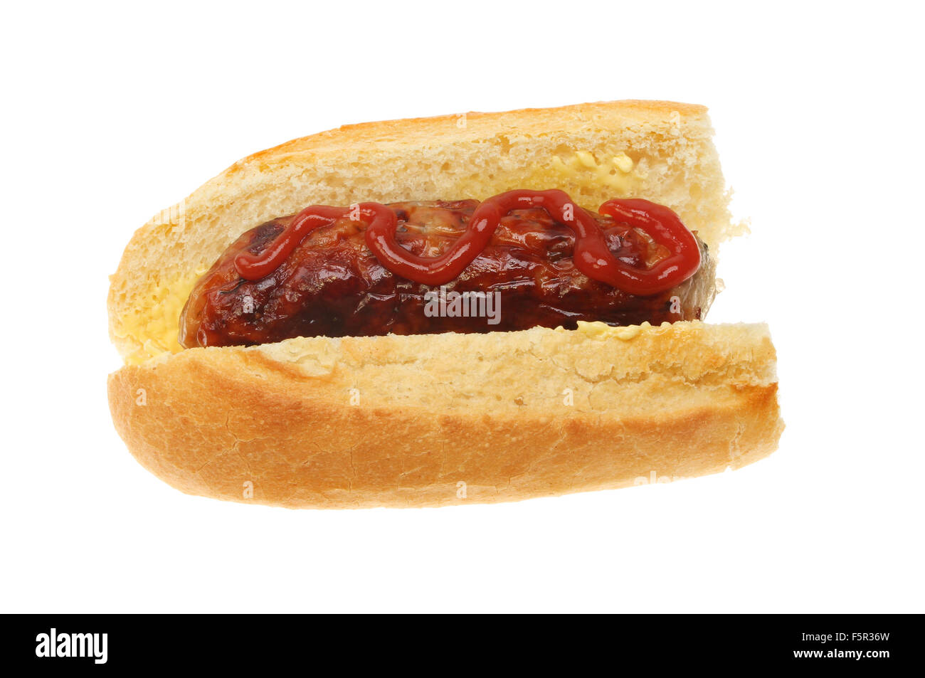 Salchichas con ketchup en una baguette aislado contra un blanco Foto de stock
