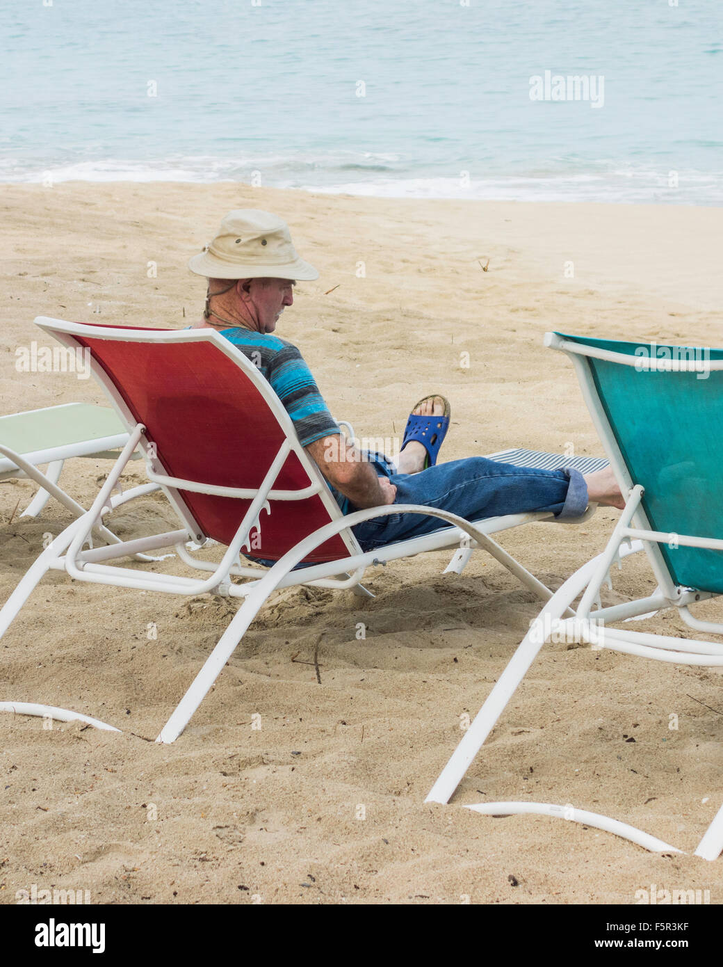 Un anciano hombre Caucásico se relaja en una silla de playa en la playa de Saint Croix, Islas Vírgenes de EE.UU. Foto de stock