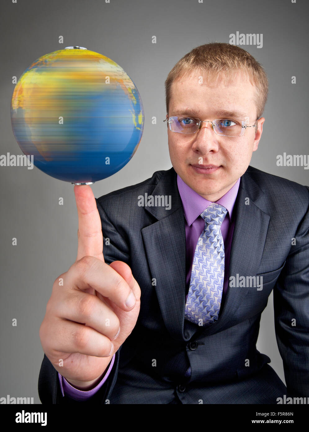 Retrato de hombre de negocios serio, haciendo girar el globo terráqueo en  dedo Fotografía de stock - Alamy