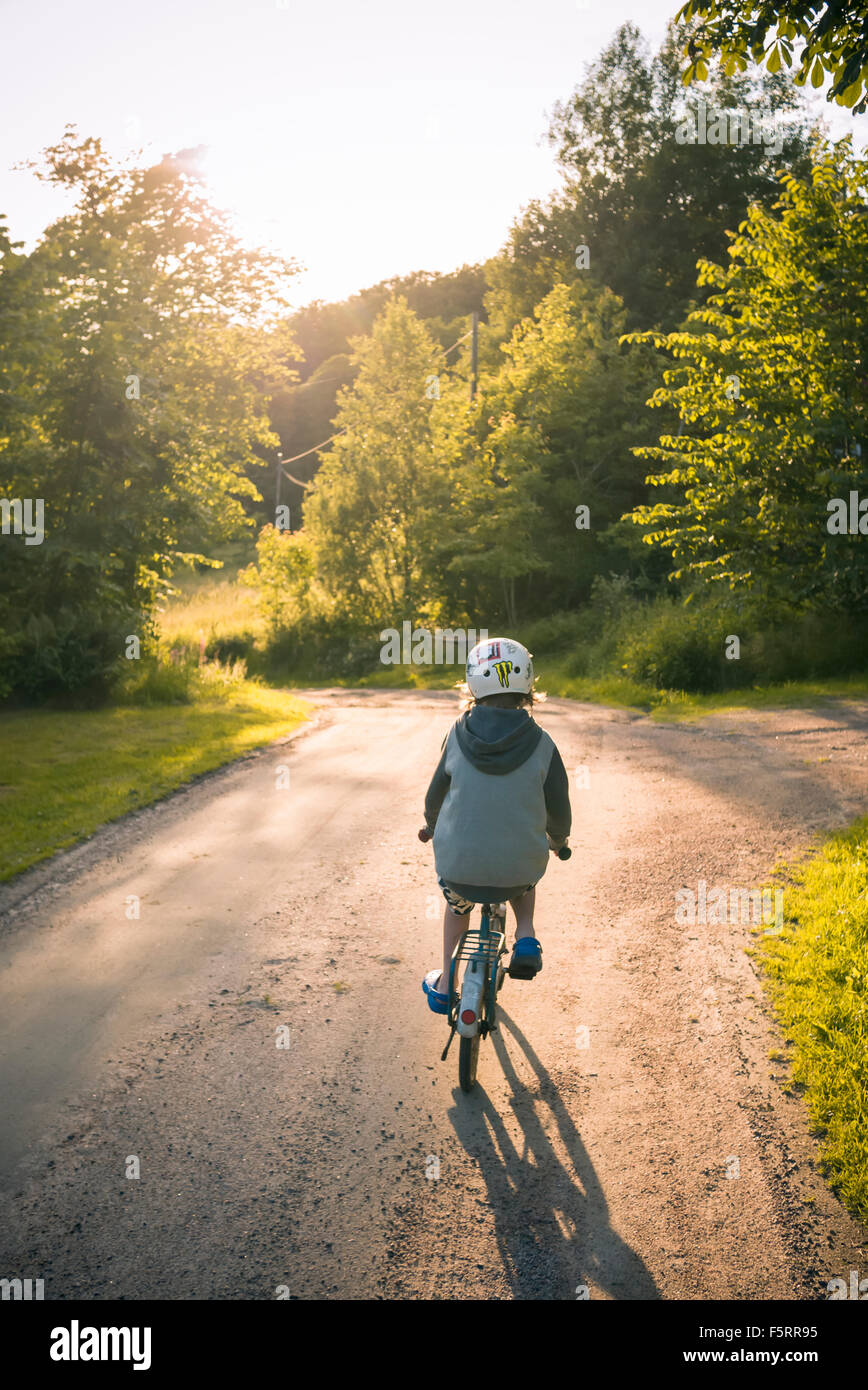 Suecia, Bohuslan, Halleback, Boy (10-11) Ciclismo de distancia a lo largo de caminos de asfalto Foto de stock