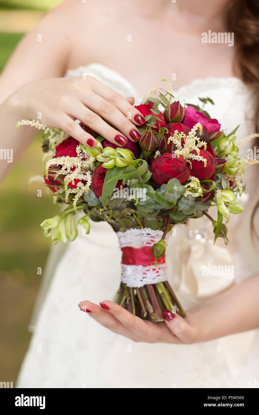 Ramo de novia con rosas rojas en sus manos Fotografía de stock - Alamy