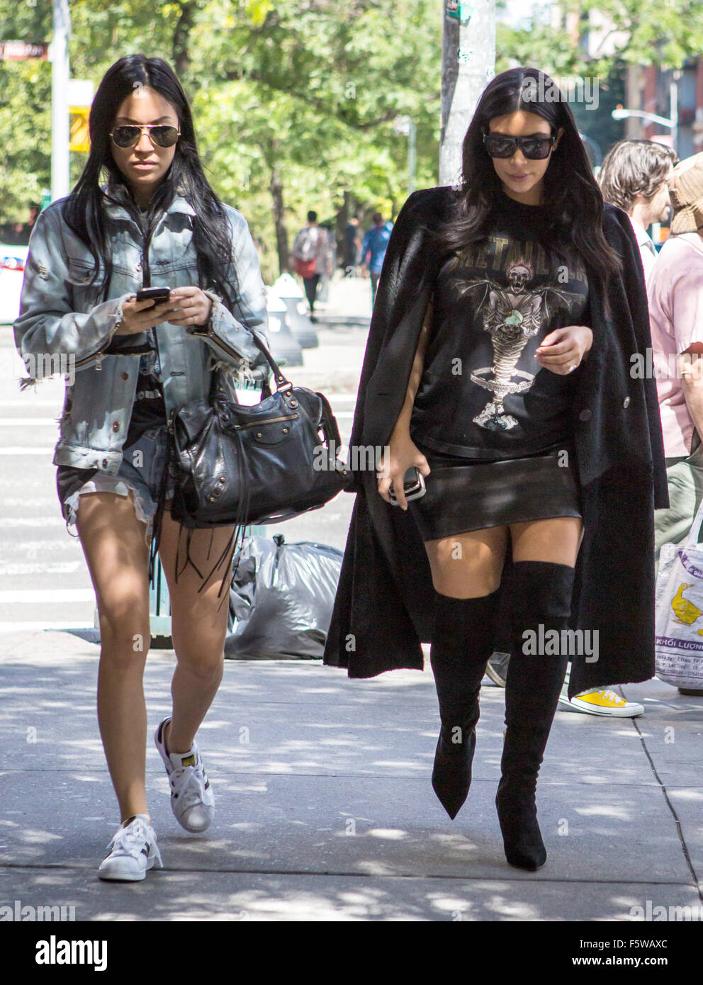 Kim Kardashian, vistiendo un largo abrigo negro, negro botas altas y una camiseta de Metallica, cabezas para cenar con un amigo en el Soho durante la Semana de la Moda de