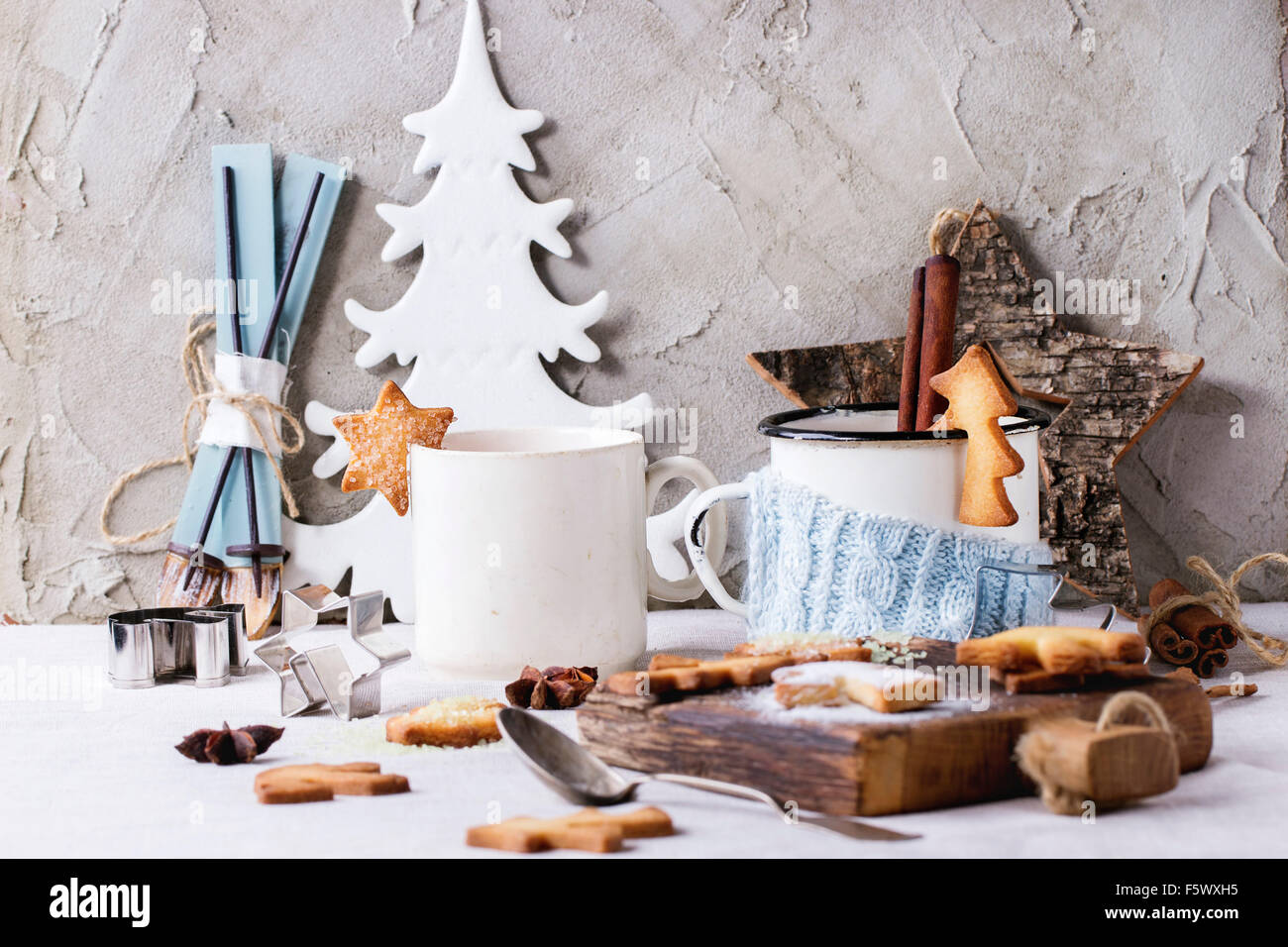 Shortbread galletas de Navidad para CUPS, dos tazas de té caliente y el azúcar en polvo sobre la mesa con mantel blanco con decoración de Navidad Foto de stock