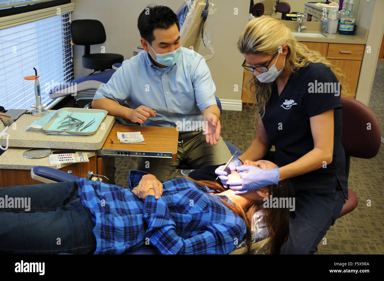 Un ortodoncista es un tipo de dentista que se especializa en enderezar dientes torcidos. Aquí con el Ayudante de Office y del paciente. Foto de stock