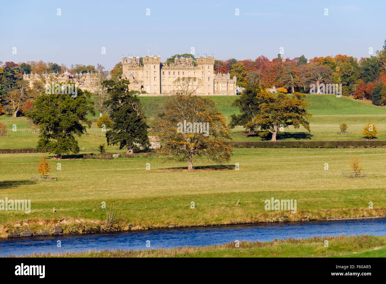 Pisos Castillo y los terrenos en otoño desde el otro lado del río Tweed. Kelso, Berwickshire, Scottish Borders, Escocia, Reino Unido, Gran Bretaña Foto de stock