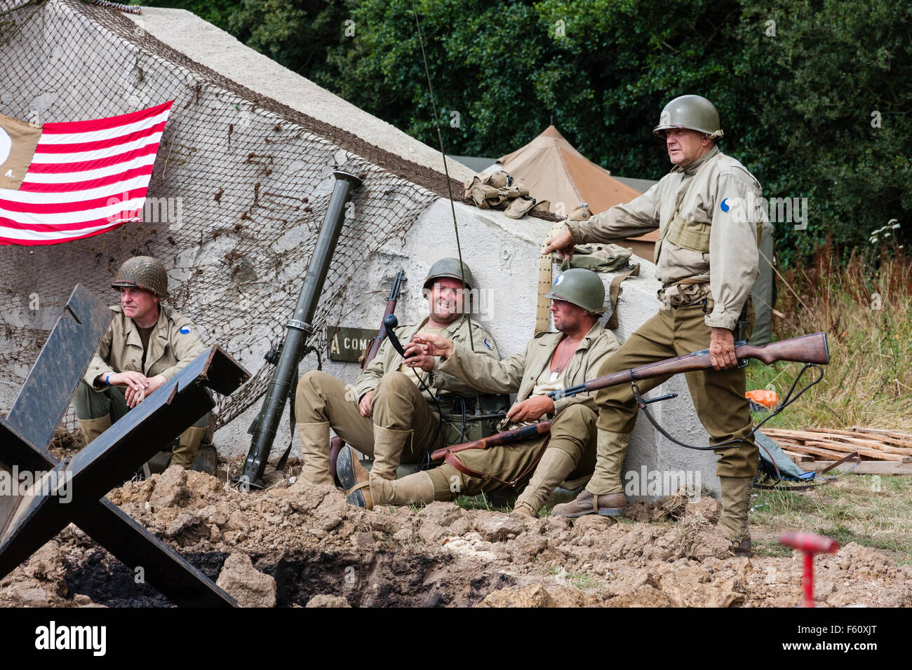 La segunda guerra mundial Re-promulgación. Un grupo de soldados americanos  sentados por bunker Alemán, chatear y relajante. Diversos uniformes  Fotografía de stock - Alamy