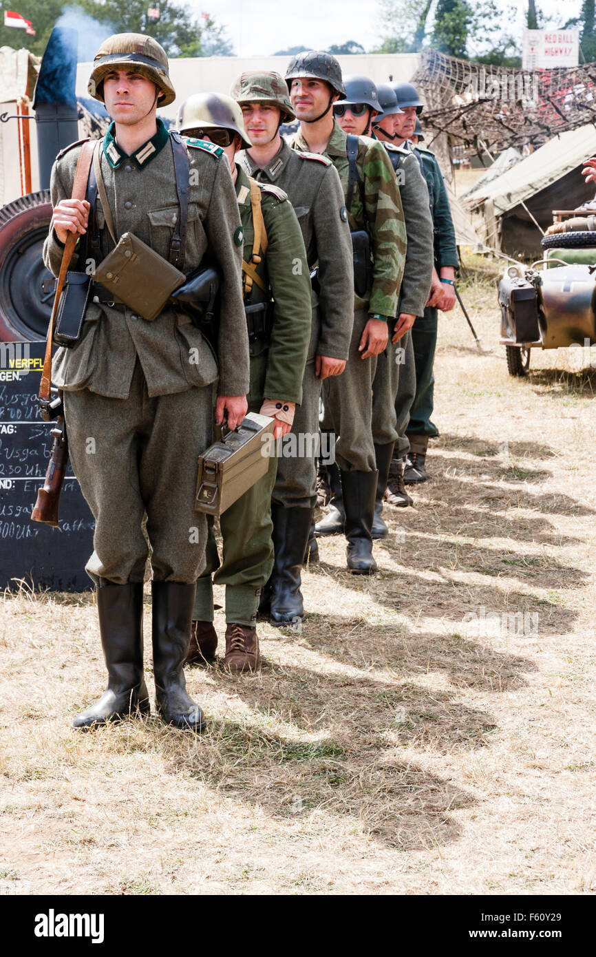 La segunda guerra mundial re-promulgación. Línea de soldados alemanes en la  atención permanente en único archivo hacia el visor. La brillante luz del  sol, al aire libre Fotografía de stock - Alamy