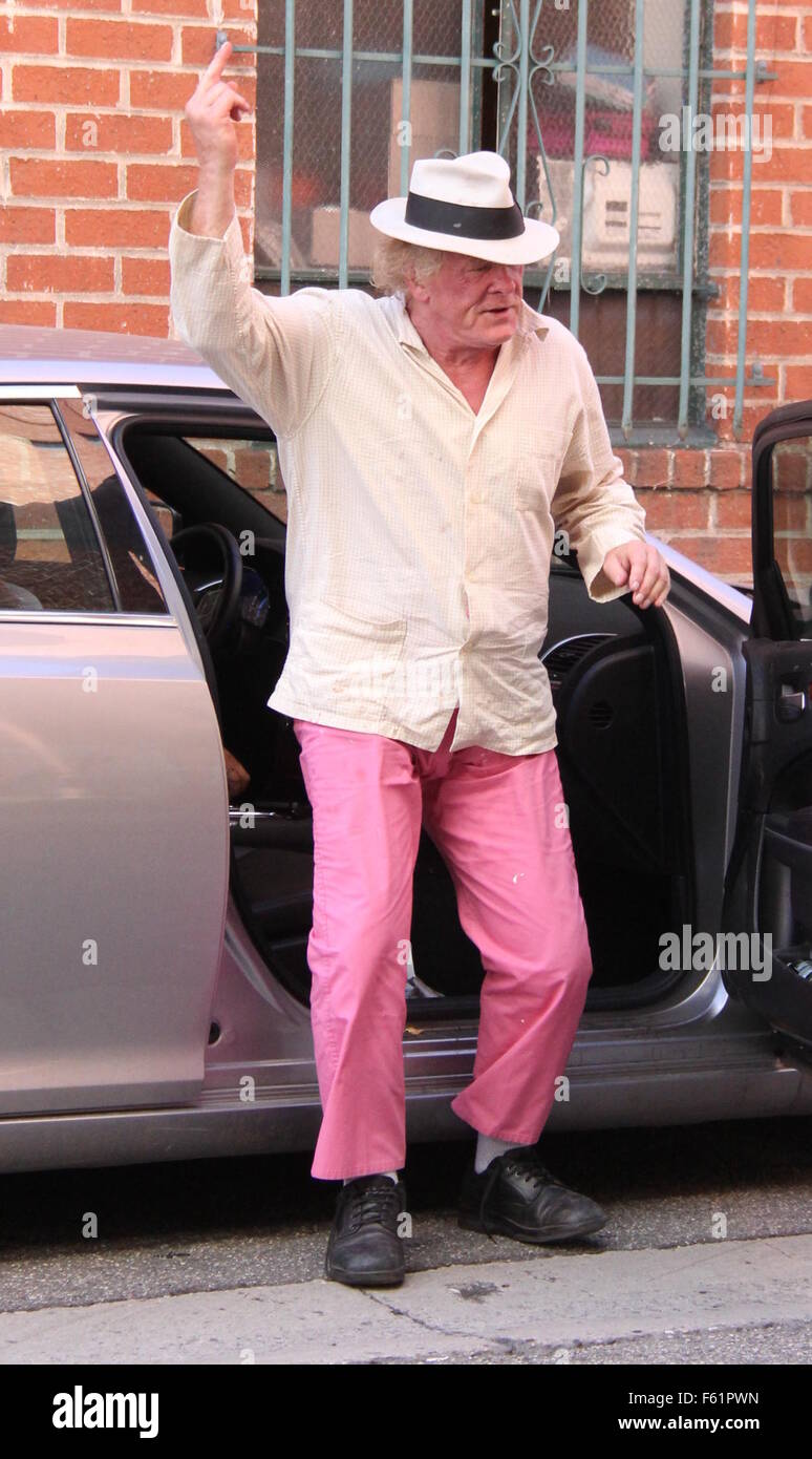 Actor Veteren Nick Nolte obtiene de su automóvil vistiendo ropa no  coincidentes de beige camisa rosa, pantalones, calcetines blancos y zapatos  negros sin los cordones atados y un sombrero de un tamaño