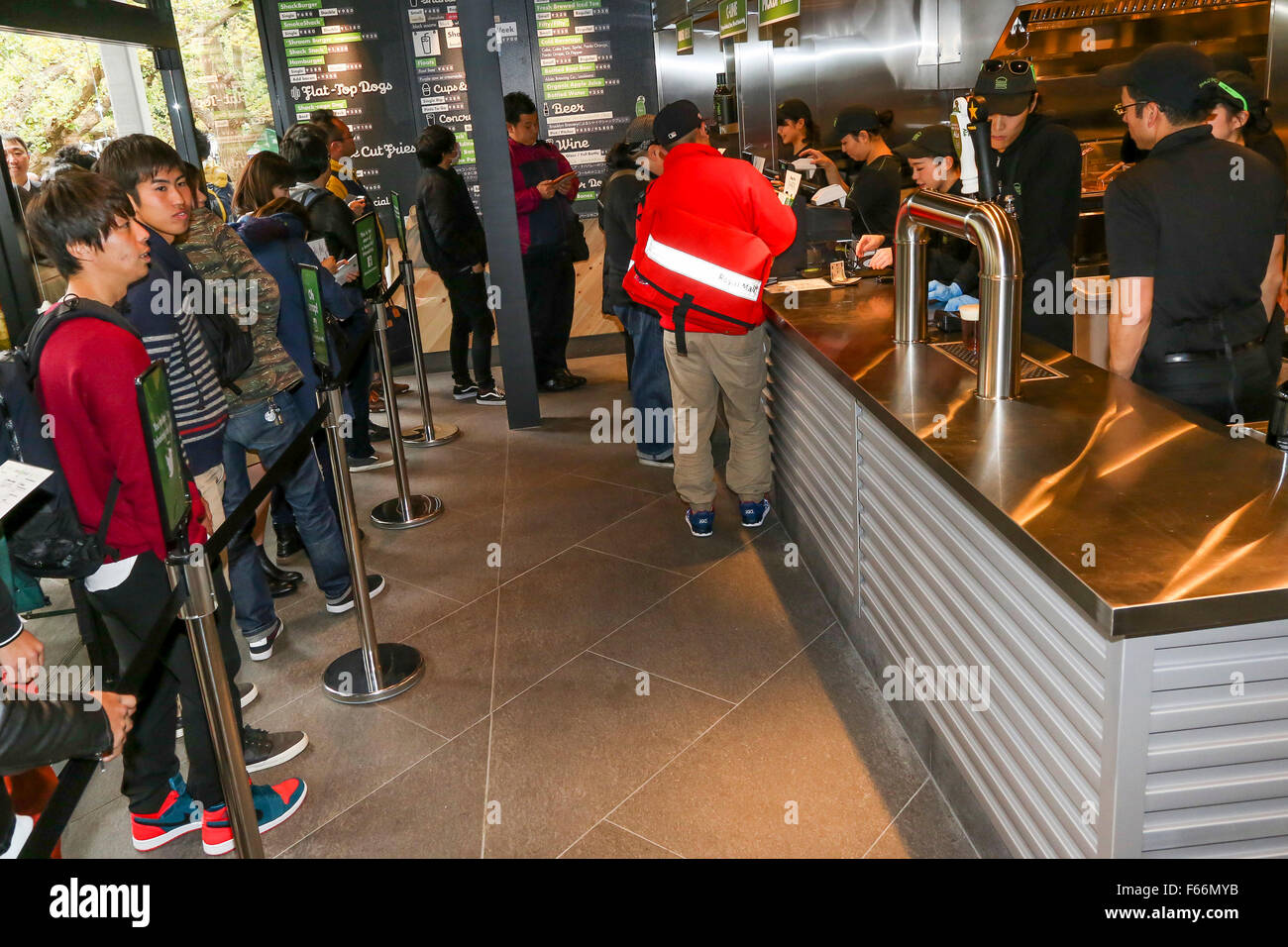 El personal del nuevo Burger restaurant Shake Shack tomar órdenes de los clientes durante la apertura del evento el 13 de noviembre de 2015, Tokio, Japón. Aproximadamente 400 personas se alinearon para obtener una primera degustación de la ShackBurger, SmokeShack o choza cago Perro. Nuevas aperturas de nosotros las cadenas alimentarias son un gran negocio en Japón, y fue presentado en la tienda muestra desayuno japonés. Según los organizadores, la gente comenzó a alinear a partir de las 9:30 pm de la noche anterior. © Rodrigo Reyes Marin/AFLO/Alamy Live News Foto de stock