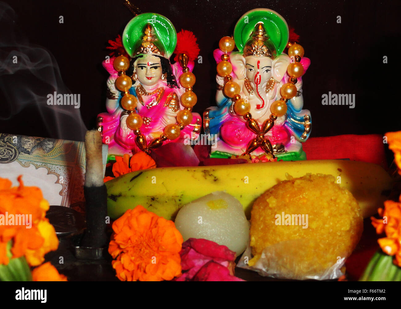 Diosa devocional Maa Lakshmi y el Señor Ganesha estatua con algunos dulces y frutas Foto de stock