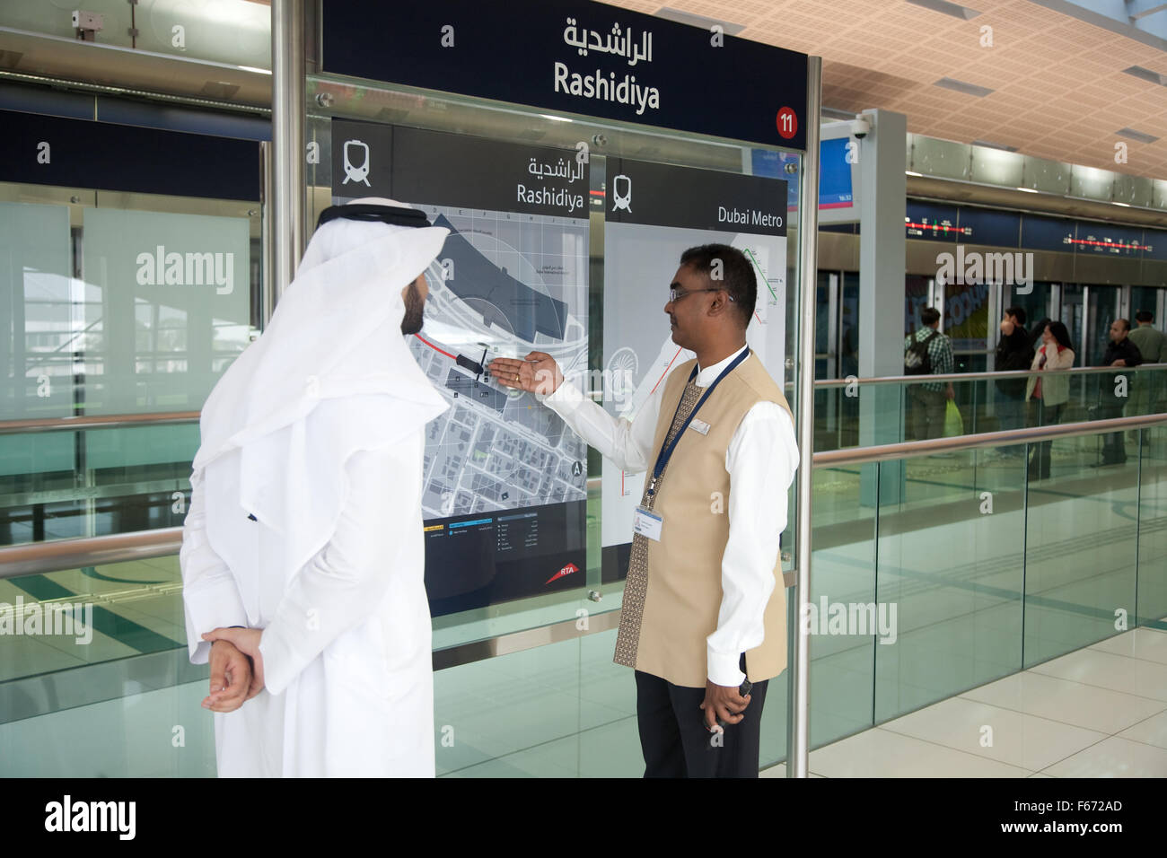 Hombre árabe está dando información del miembro del personal del Metro de Dubai Foto de stock