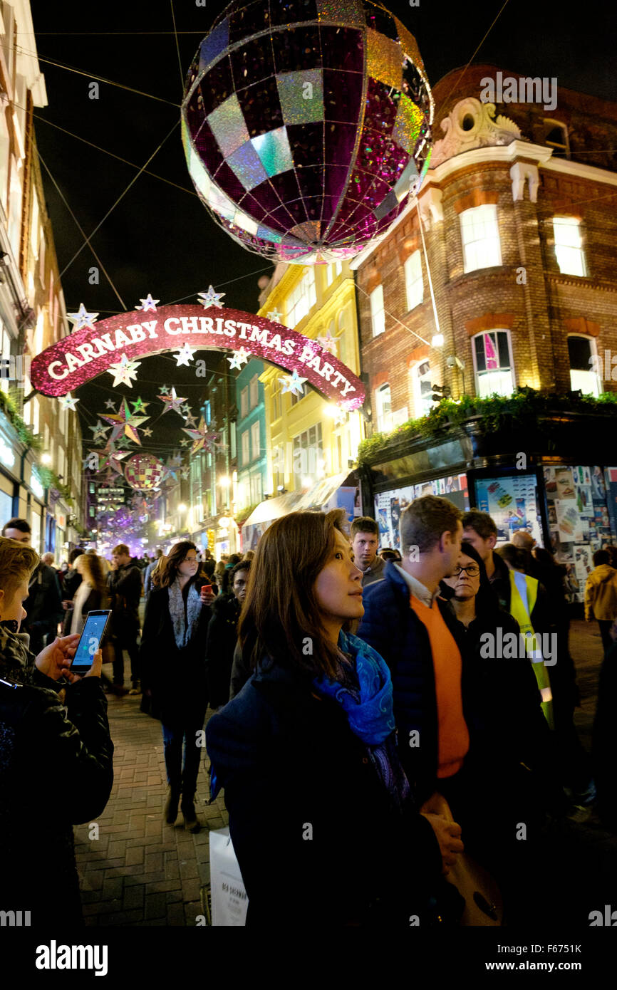Carnaby Street, Londres, 12 de noviembre de 2015: En un día relativamente cálido, los compradores y los turistas están en las calles del West End de Londres para la fiesta de Navidad Carnaby el encendido de la bola de discoteca themed las luces de Navidad. Foto de stock
