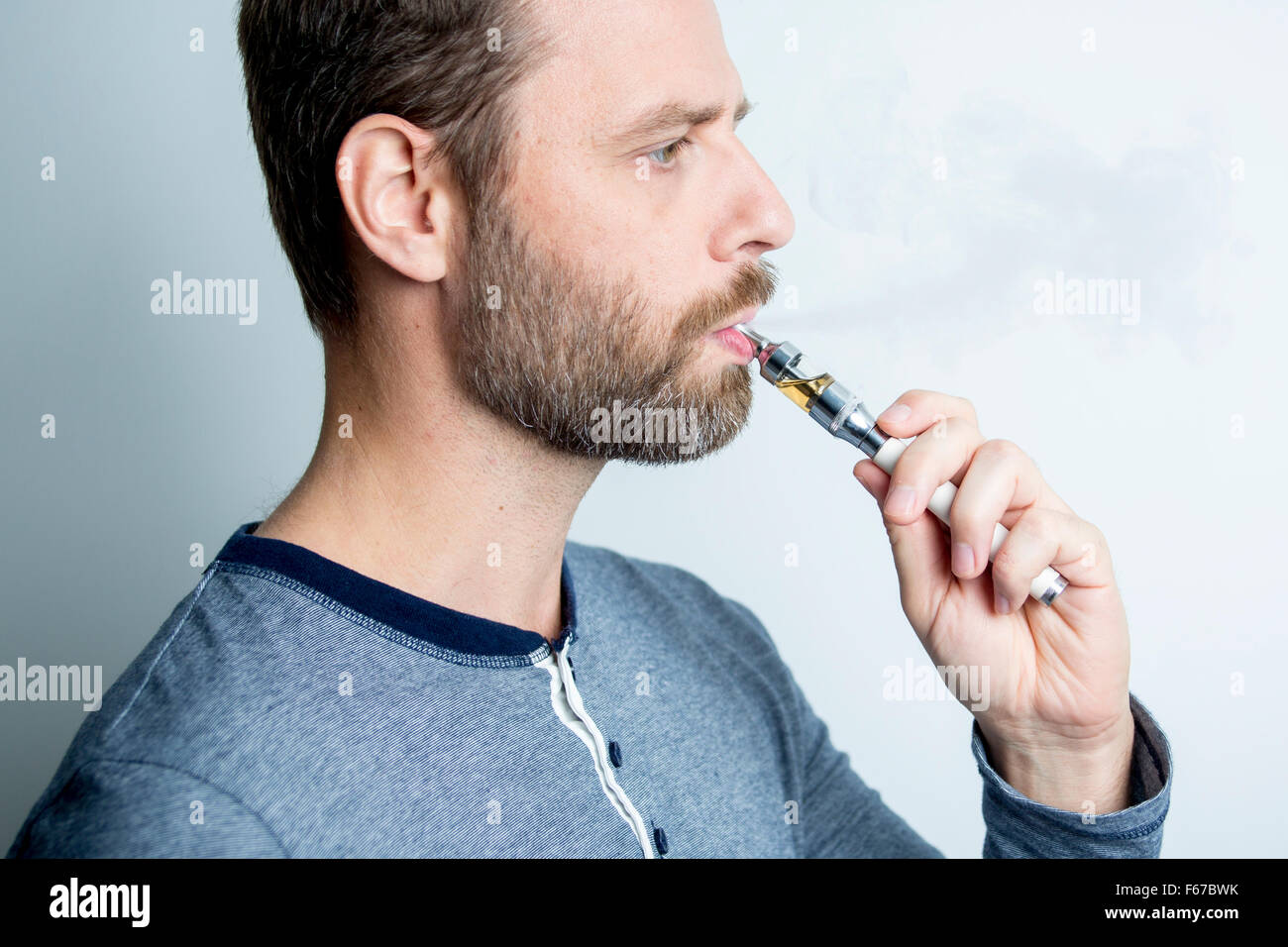 Retrato de un hombre joven de fumar cigarrillo eléctrico Foto de stock