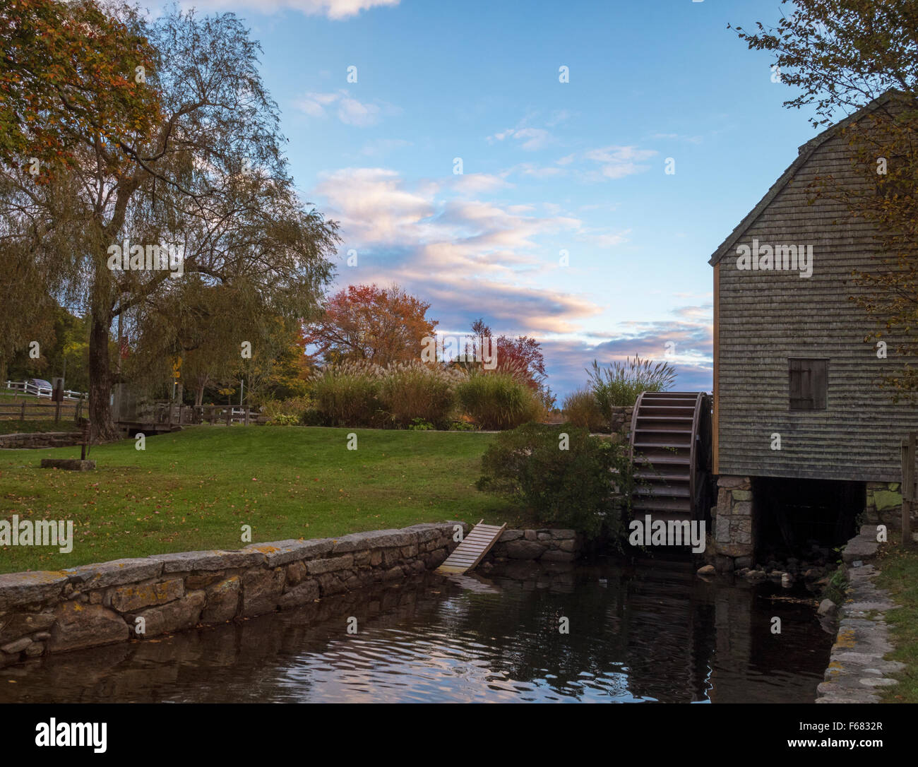 Histórico Molino Dexter Grist, Sandwich, Cape Cod Massachusetts Estados Unidos con undershot rueda de agua de madera y millrace color en el otoño. Foto de stock