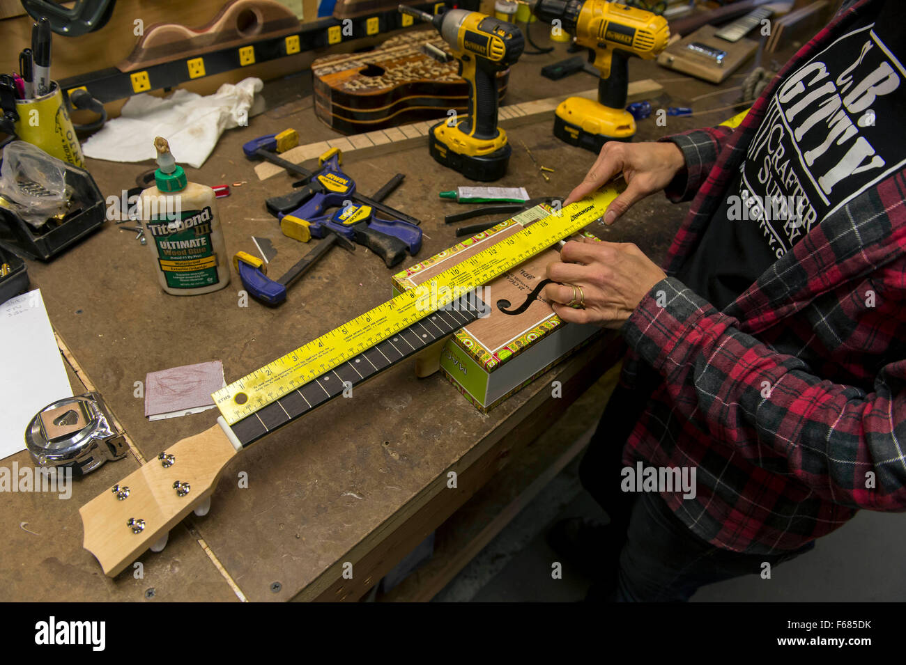 Rochester, New Hampshire, Estados Unidos. 13 Nov, 2015. Constructor de  Instrumentos FARLEY ANDRESEN trabaja sobre un Ukelele Tienda en C. B. Gitty  artesano la oferta. Fundada en propietario Ben Baker el sótano