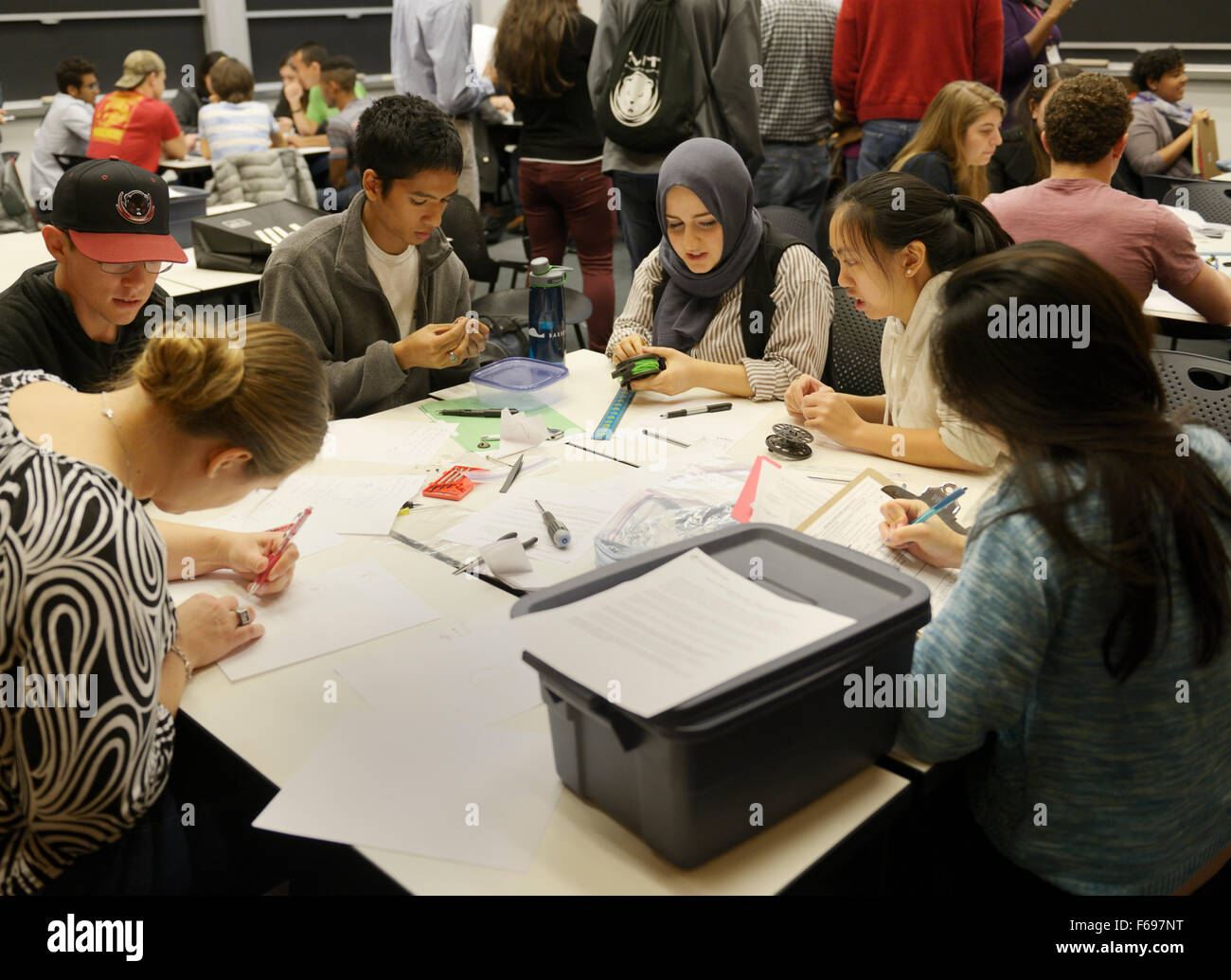 Aula universitaria, ingeniería eléctrica clase con diversidad étnica y de género - grupo de estudiantes universitarios que colaboran en un problema, MIT Foto de stock