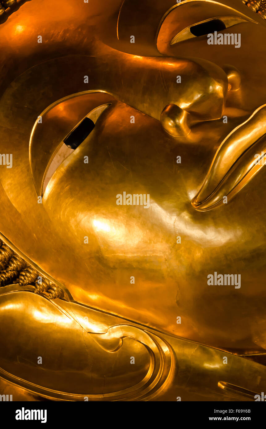Cara de oro estatua de Buda Reclinado de Wat Pho, en Bangkok, Tailandia. Foto de stock