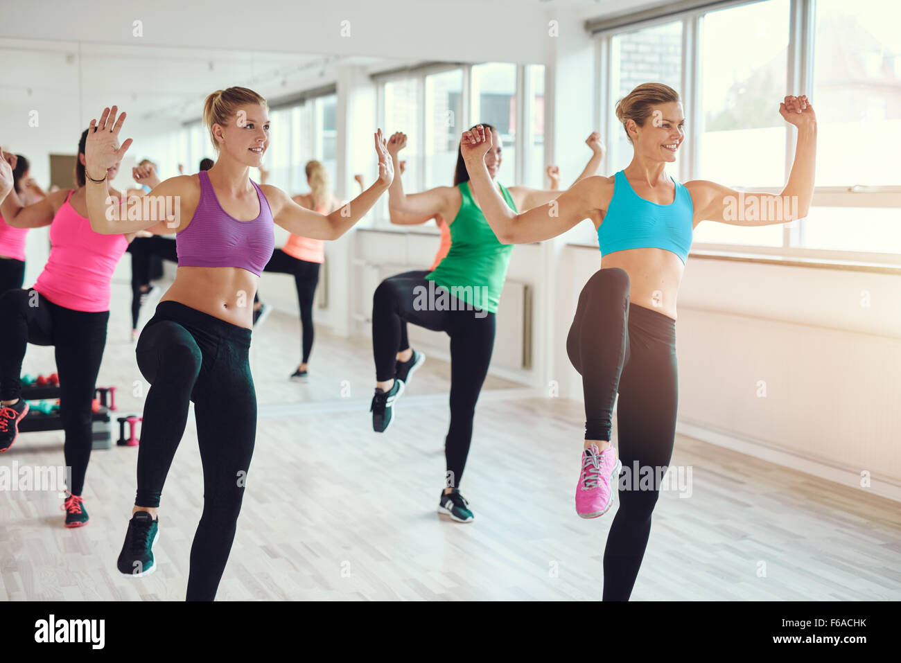 Gimnasio, el deporte, la formación, el gimnasio y el concepto de estilo de vida - grupo de gente sonriente el ejercicio en el gimnasio. Foto de stock
