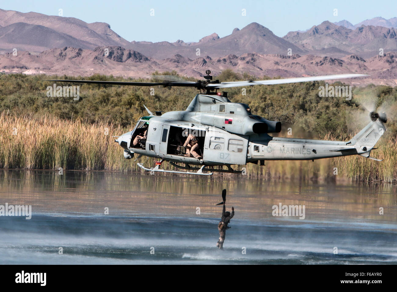 Un marine estadounidense con la 1ª Compañía de Reconocimiento de la fuerza, la Primera Fuerza Expedicionaria de la Marina realiza un ejercicio helocast fuera de un UH-1Y Venom en Ferguson Lake, cerca de Yuma, Arizona, el 3 de octubre de 2015. El ejercicio es parte de armas y tácticas Instructor (WTI) 1-16, un evento de capacitación de siete semanas organizado por la Aviación Marina armas y tácticas de escuadrón MAWTS Uno (cuadro 1). MAWTS-1 proporciona entrenamiento táctico estandarizado y certificación de calificaciones de instructor de la unidad de apoyo a la formación y preparación de la Aviación Marina y colabora en el desarrollo de la aviación y empleando armas y tácticas. (Ee.Uu. Marine Corps photog Foto de stock