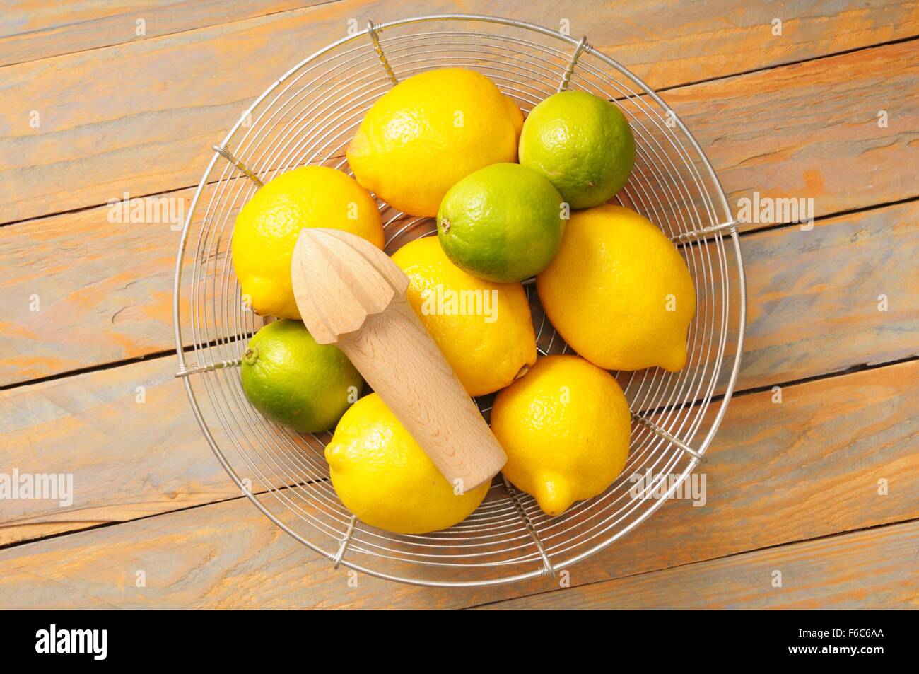 Los limones y limas en una cesta de alambre con un exprimidor de limón  Fotografía de stock - Alamy