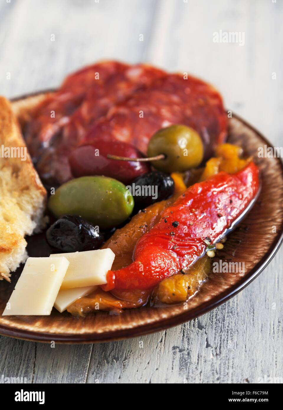 Antipasto con fuego asado pimientos rojos y amarillos, mezclado Olivas