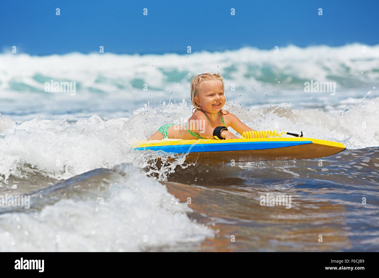 Little Baby Girl - joven surfista con bodyboard tiene diversión en las pequeñas  olas del mar Fotografía de stock - Alamy