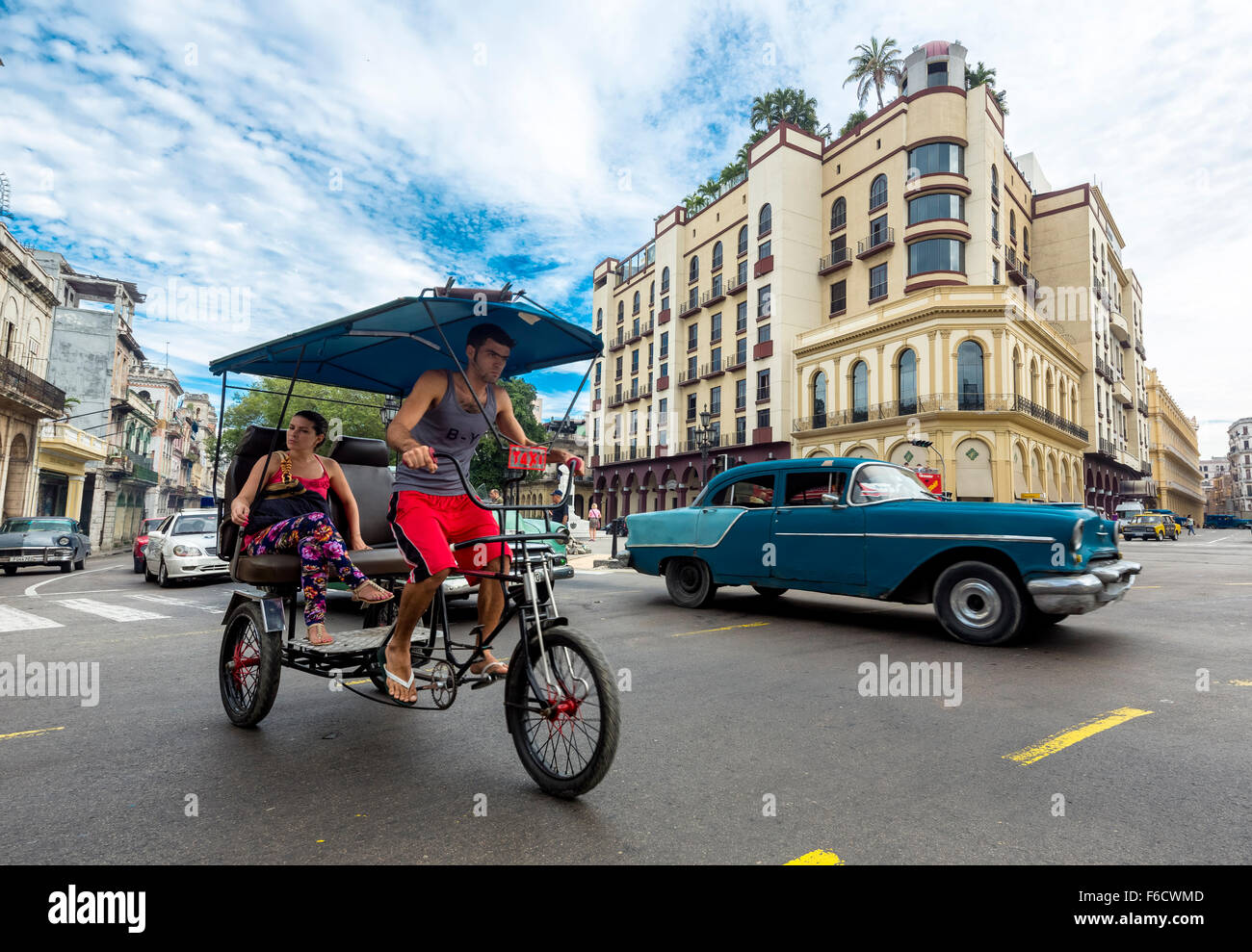 Oldtimer en el paisaje urbano, el triciclo, la gente taxi en la intersección de la calle cerca del Hotel Telégrafo, escena de una calle, La Habana, Foto de stock