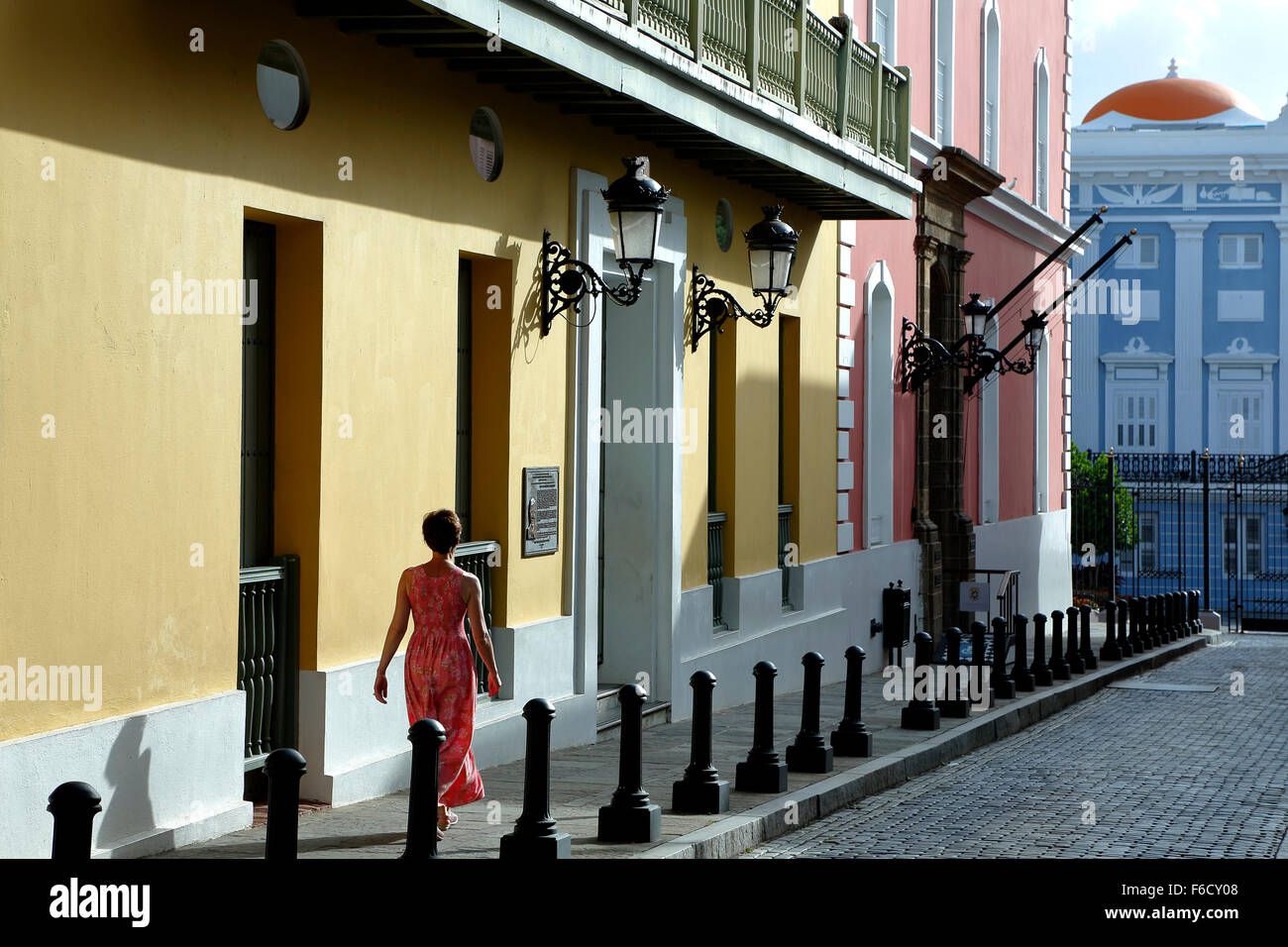 Mujer y coloridas fachadas coloniales españolas (Oficina Estatal de Preservación Histórica), Calle Fortaleza, el Viejo San Juan, Puerto Rico Foto de stock