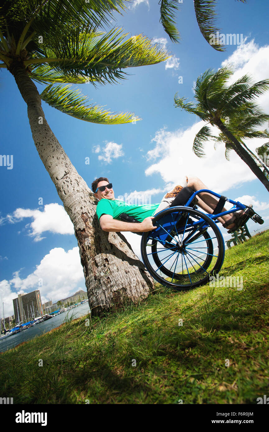 Hombre con discapacidad jugando en silla de ruedas en la playa Foto de stock