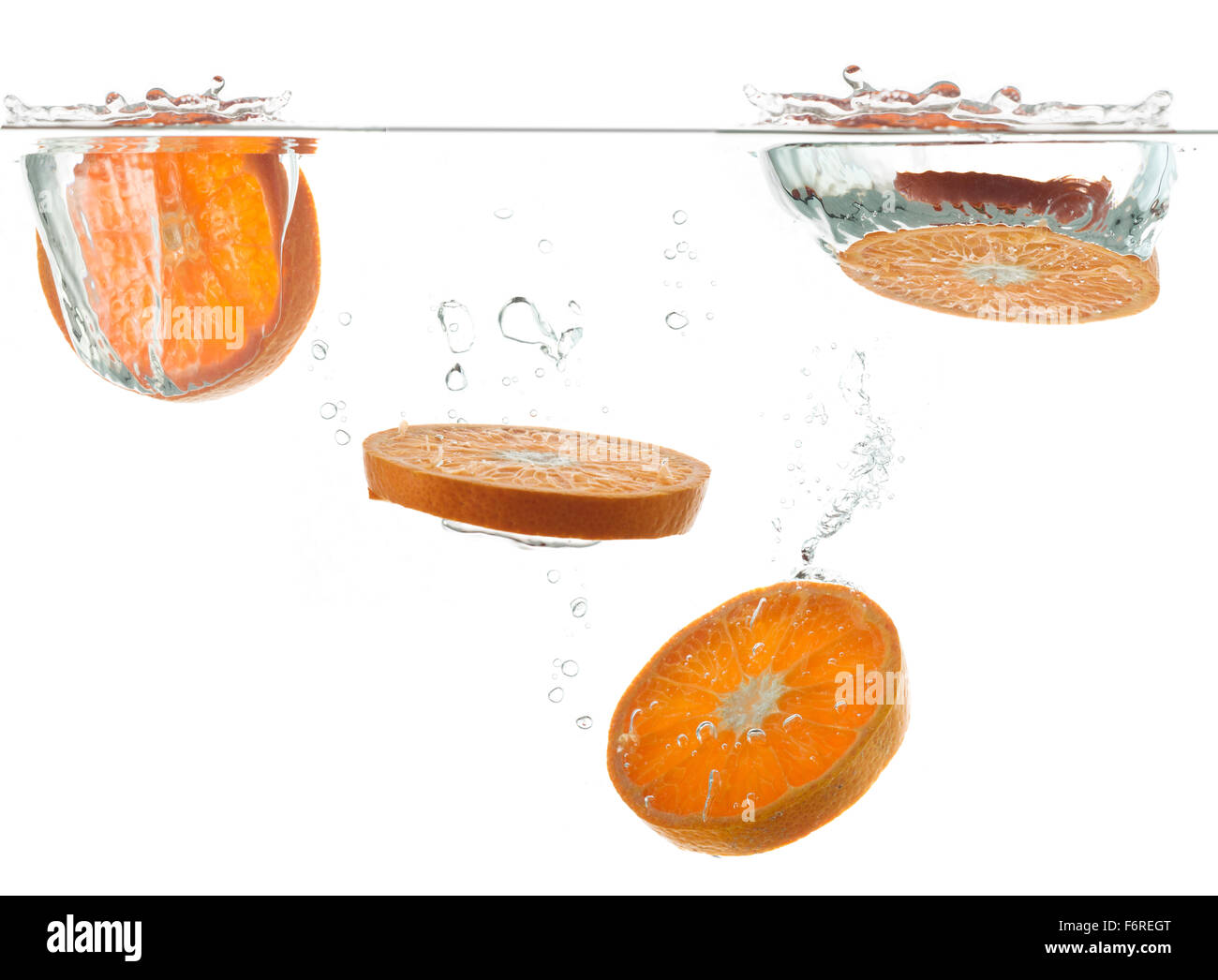 Las naranjas de caer en el agua con un chorrito Foto de stock