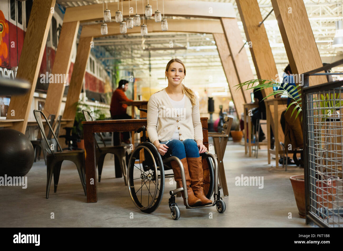 Mujer sentada parapléjico en silla de ruedas en el café Foto de stock
