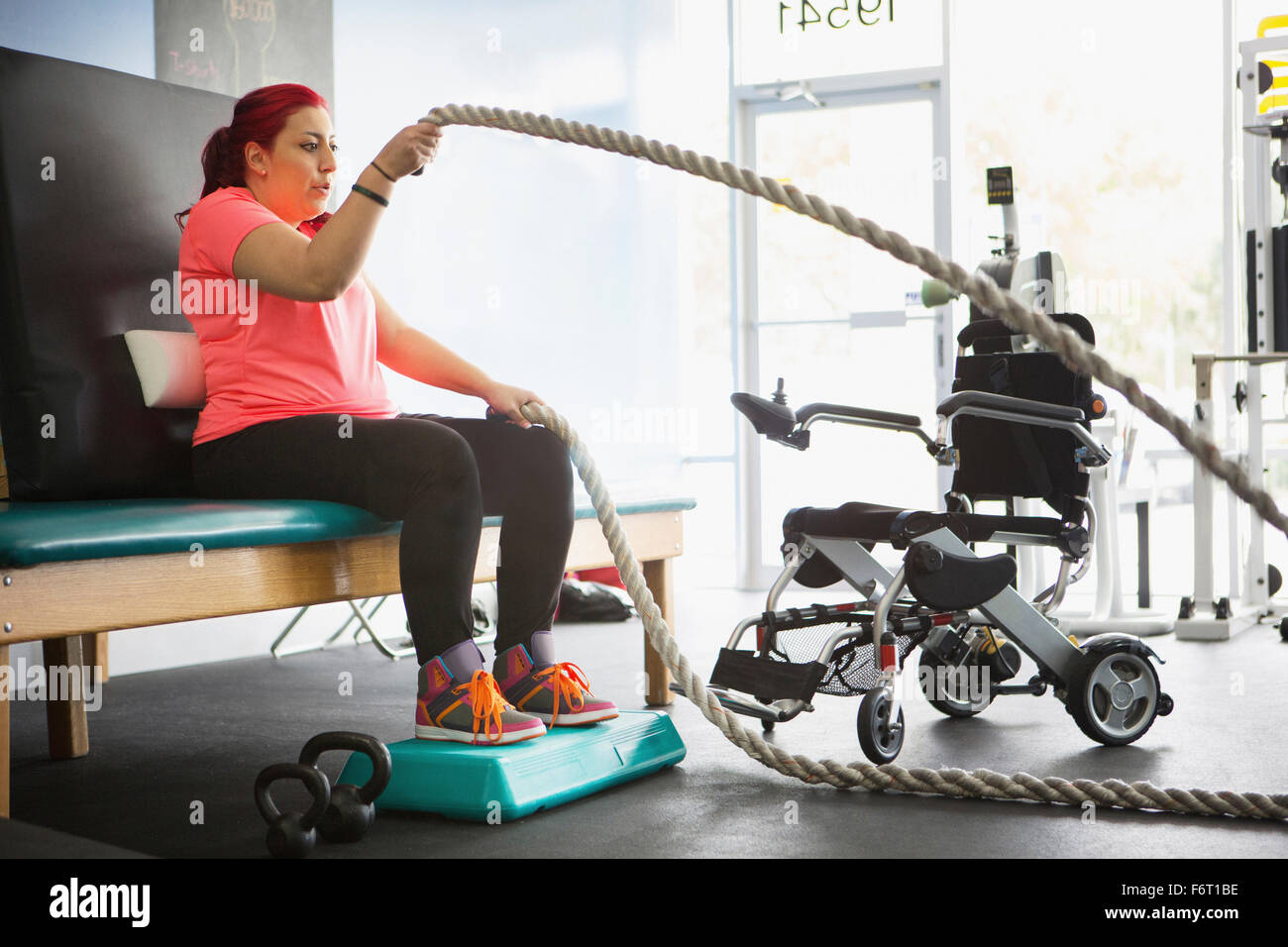 Mujer discapacitada haciendo terapia física en el gimnasio Foto de stock