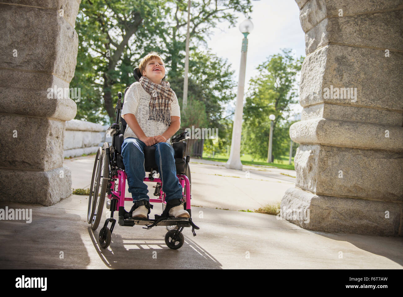 Mujer parapléjico en silla de ruedas bajo el arco de piedra Foto de stock