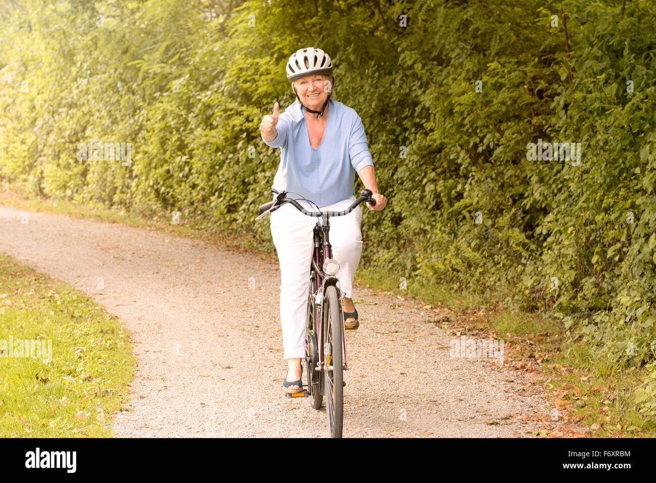 Hombre guapo ciclista en ropa deportiva y casco de pie con bicicleta en  carretera rural. Actividad al aire libre y estilos de vida saludables  Fotografía de stock - Alamy