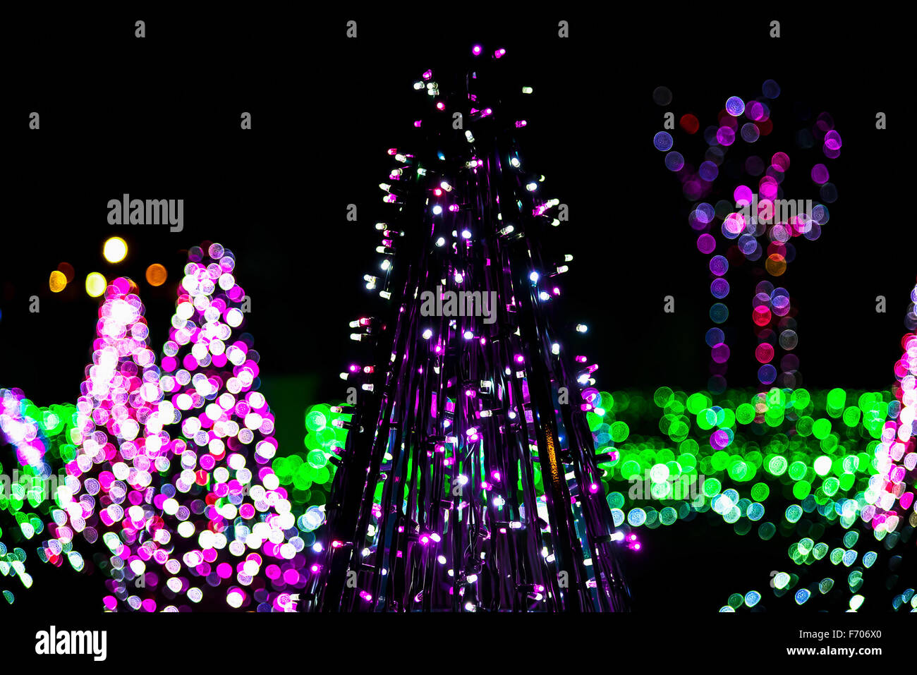 Construcción de árbol de Navidad desde cadenas de Garland en contra de coloridas Luces de Navidad Foto de stock