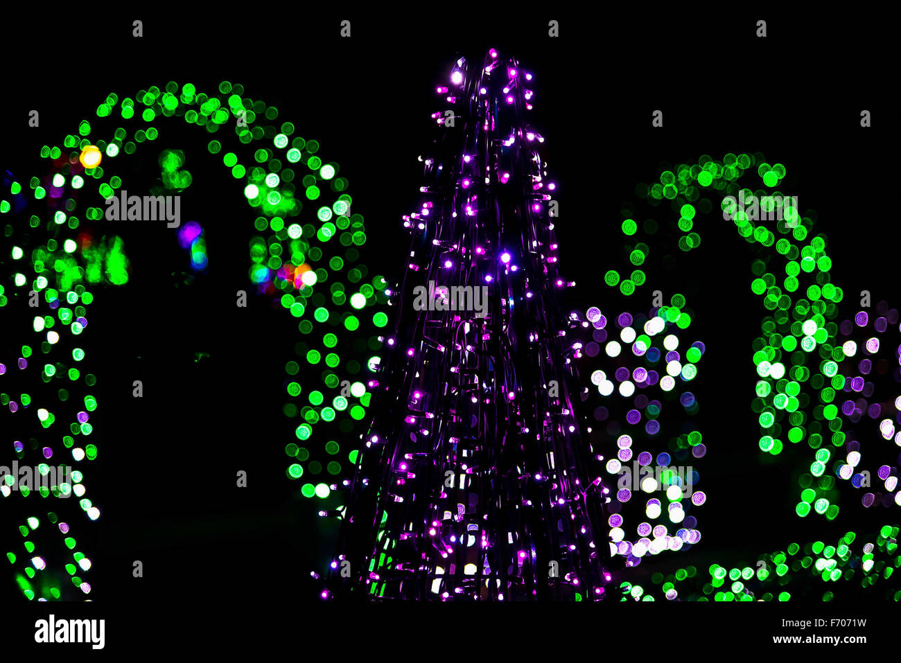En la escultura del árbol de Navidad de guirnaldas con luces verdes en la noche Foto de stock