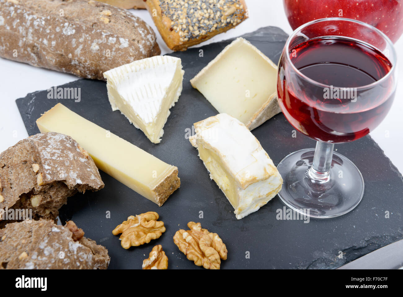 Tabla de quesos franceses con pan y una copa de vino tinto Fotografía