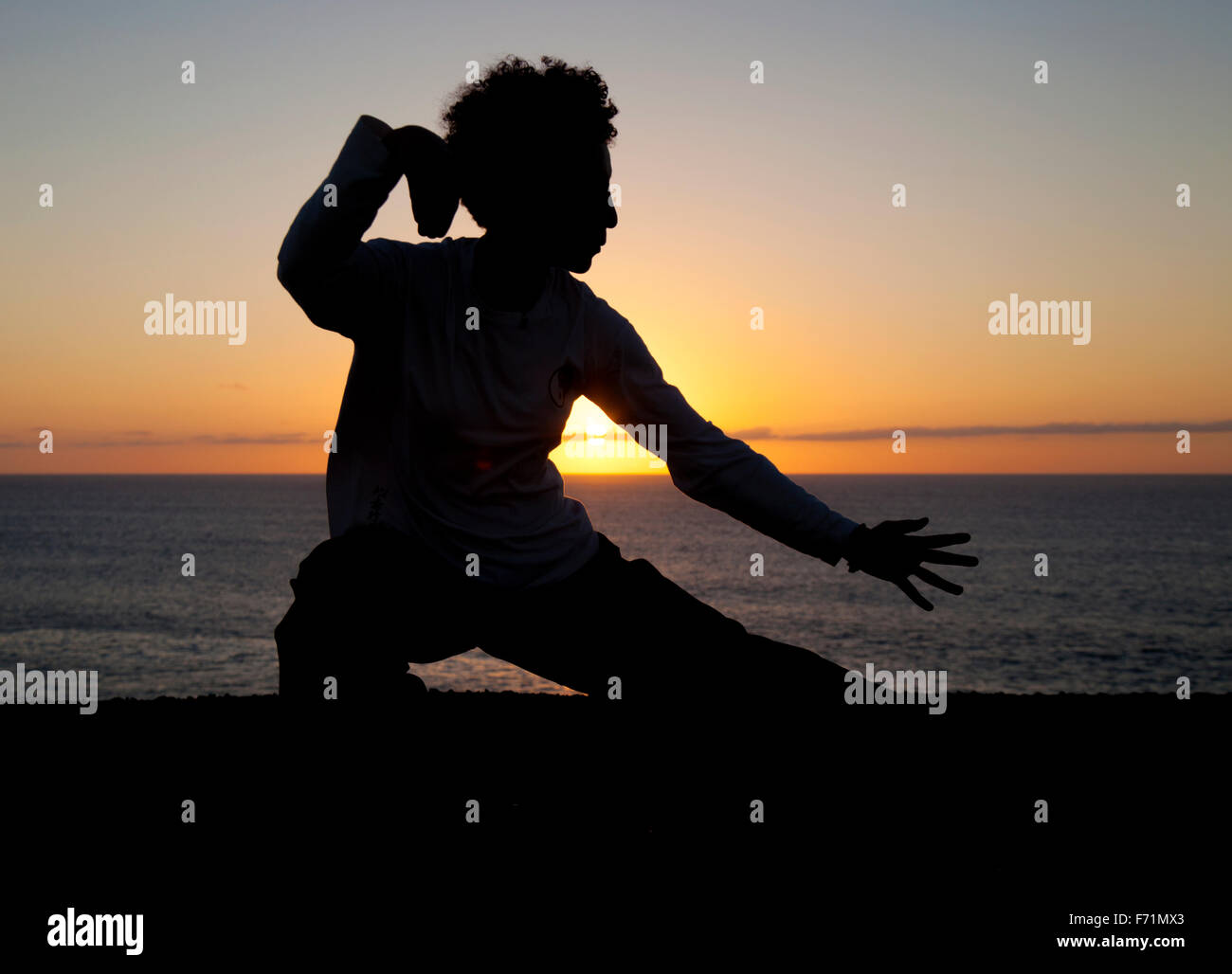 Mujer joven realiza movimientos de tai chi silueteado contra sunset  Fotografía de stock - Alamy