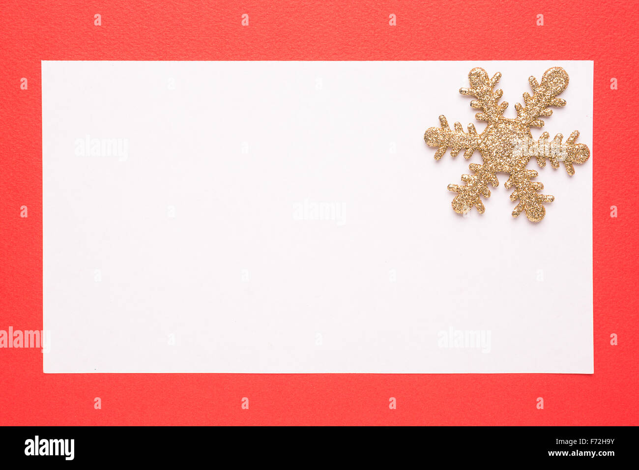 Tarjeta de Navidad en blanco o invitación con copo de nieve sobre fondo rojo. Foto de stock